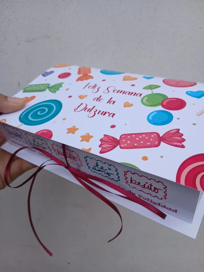 Caja personalizada ilustrada con caramelos y la frase Feliz Semana de la Dulzura, atada con una cinta bordó